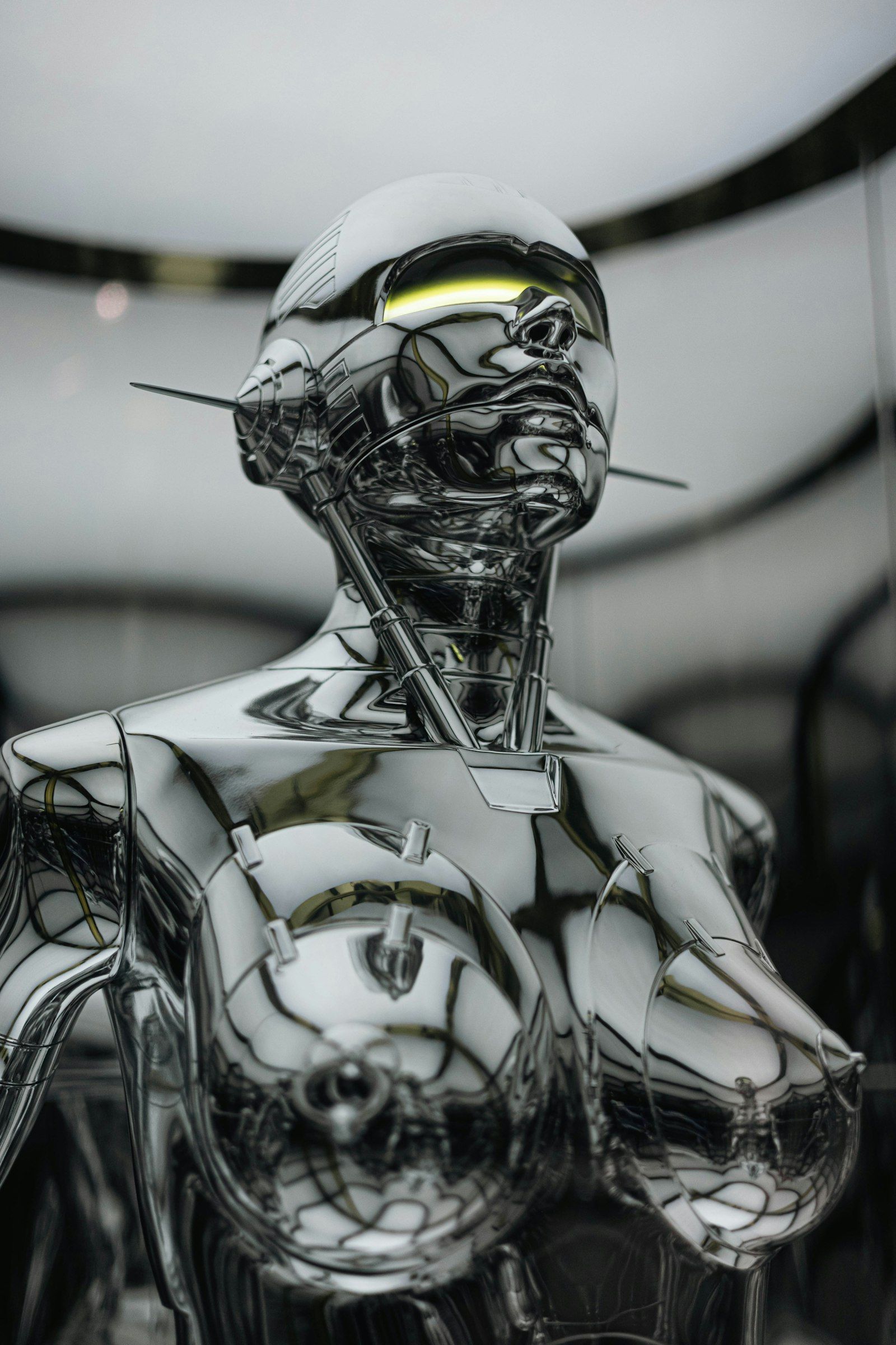 A highly polished chrome humanoid robot bust with glowing eyes