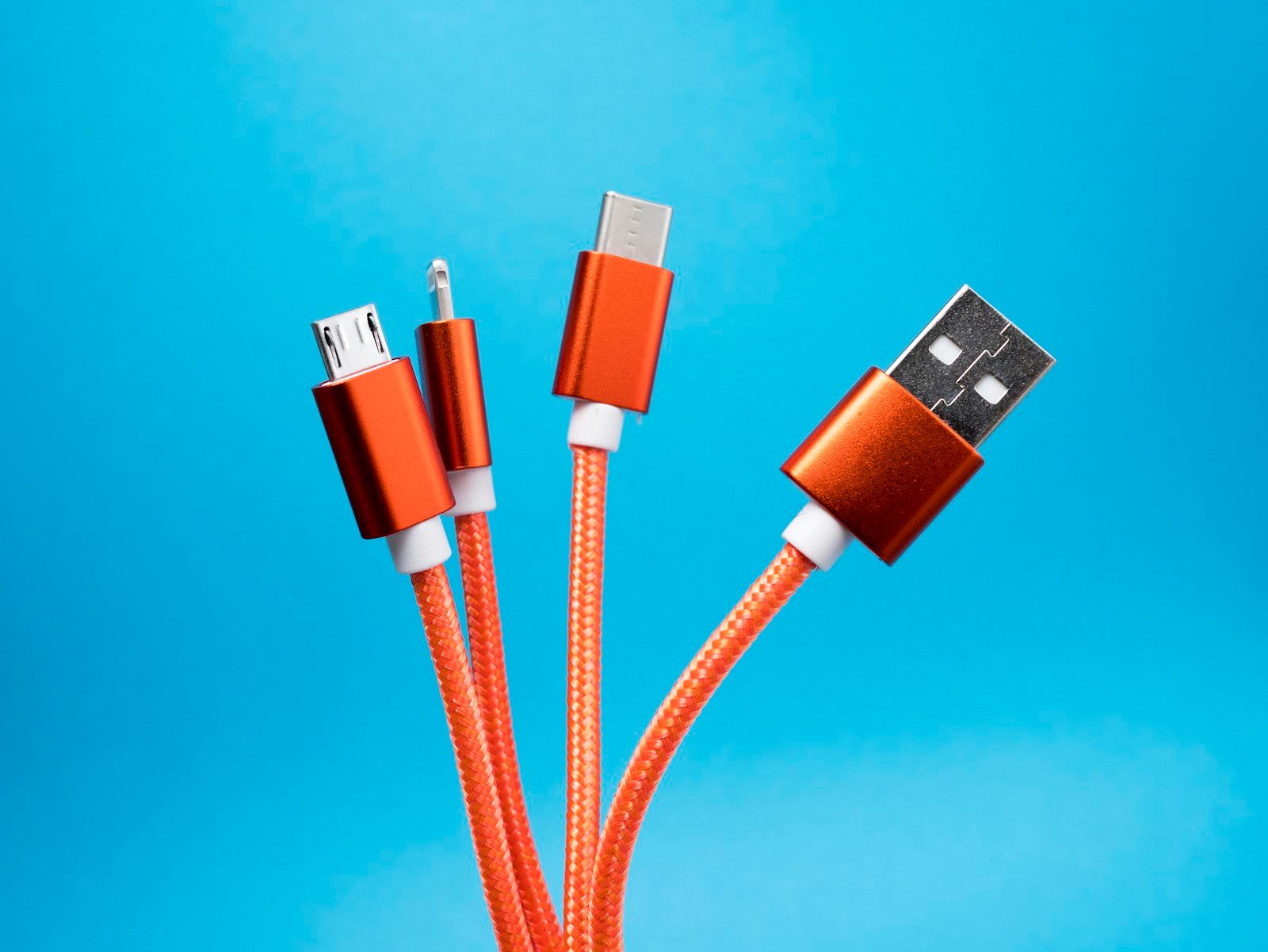Orange USB charging cables arranged together — connectivity as a standard